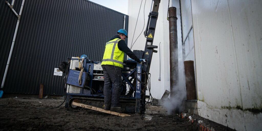 Ten Napel medewerker bezig met een mini heimachine